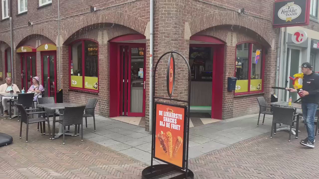 Draaiend stoepbord van Mora die voor een cafetaria staat
