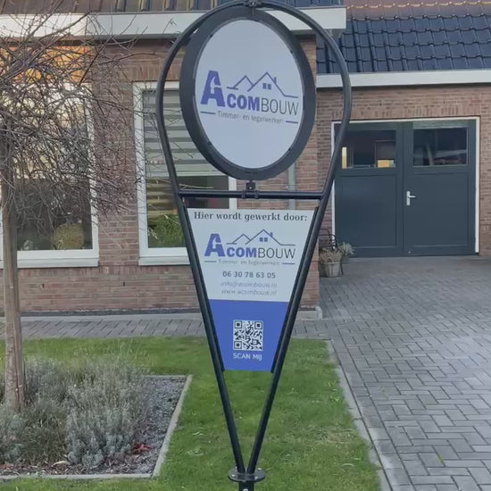 Draaiend reclamebord van Acombouw die in de tuin staat voor zijn werklocatie 